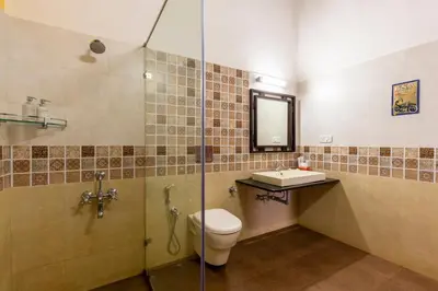 a bathroom with a shower and a toilet and a sink at amã Stays & Trails, Rare Earth Estate in Madikeri