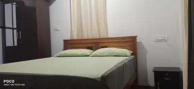 a bedroom with a bed with two pillows on it at Family villa is a hut style accommodation in Tariyod
