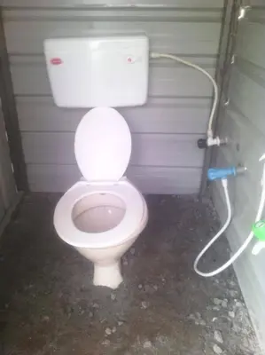 a bathroom with a white toilet in a stall at Swiss Tents in Ooty, Tn in Ooty