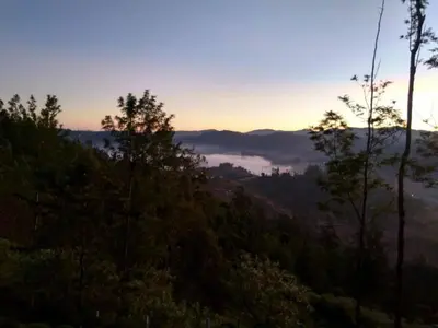 a view of a valley at sunset with trees at Swiss Tents in Ooty, Tn in Ooty