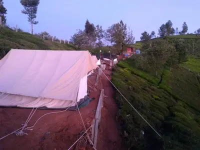 a row of tents on a hill with a fence at Swiss Tents in Ooty, Tn in Ooty