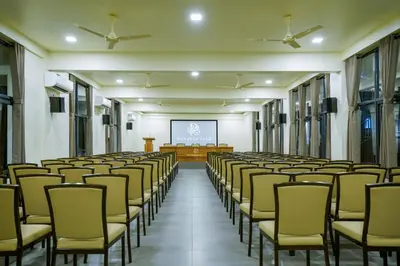 a lecture hall with rows of chairs and a screen at Fern Tree Resort in Mananthavady