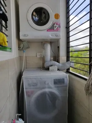 a washing machine and a dryer in a room at Swag Apartment in Mysore