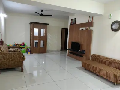 a living room with two couches and a tv at Swag Apartment in Mysore