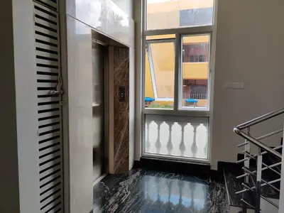 a hallway with a door and a window at Swag Apartment in Mysore