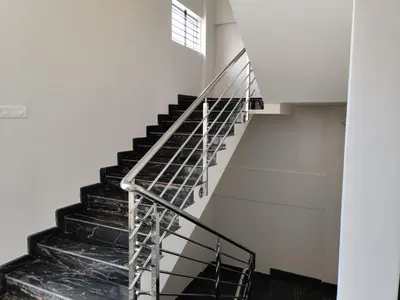 a staircase in a building with a metal railing at Swag Apartment in Mysore