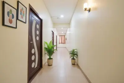 a hallway with potted plants in a building at FabHotel Manis Residency in Coimbatore