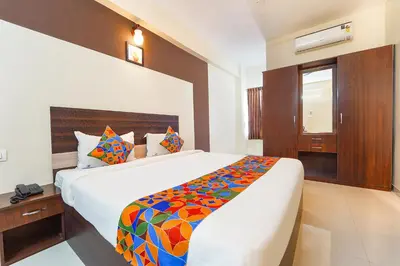 a bedroom with a large bed with a colorful blanket at FabHotel Manis Residency in Coimbatore
