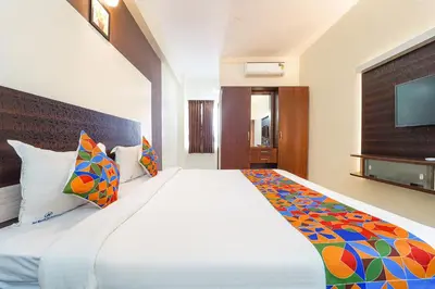 a bedroom with a large white bed with colorful pillows at FabHotel Manis Residency in Coimbatore