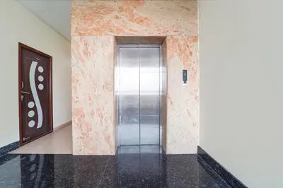 an elevator in a building with a glass door at FabHotel Manis Residency in Coimbatore