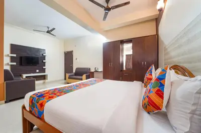 a bedroom with a bed and a living room at FabHotel Manis Residency in Coimbatore