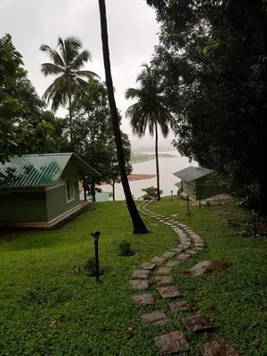a stone path in the grass next to a house at Diga vista resorts in Palakkad