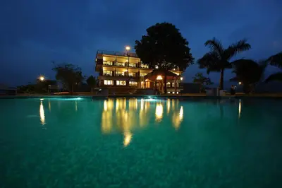 a large swimming pool at night with a building at Arayal Resort-A Unit of Sharoy Resort in Tariyod
