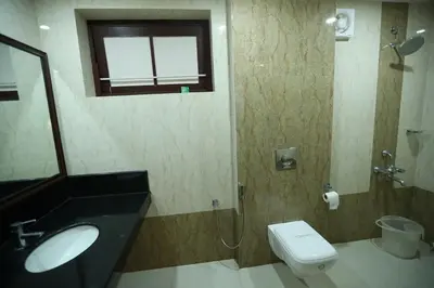 a bathroom with a sink and a toilet and a window at KTDC Garden House in Palakkad