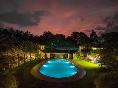 a swimming pool in the middle of a yard at night at Sterling Govardhana Malampuzha in Palakkad