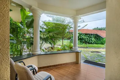 a porch with two chairs and a view of a yard at Sterling Govardhana Malampuzha in Palakkad