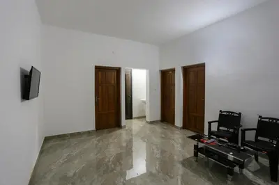 a living room with two chairs and a television at Hotel O Al Ameen Residency in Kannur