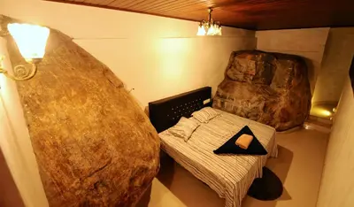 a room with a large rock and a table with a pillow at Aruvi homestay in Vythiri