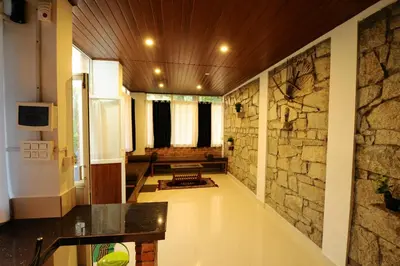 a large hallway with a stone wall and a room at Aruvi homestay in Vythiri
