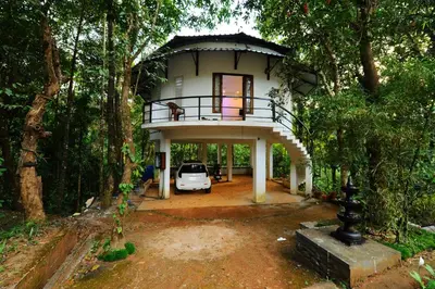 a house with a car parked in front of it at Aruvi homestay in Vythiri