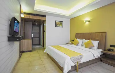 a hotel room with a bed and a tv at THE CASTELLO RESIDENCY in Coimbatore