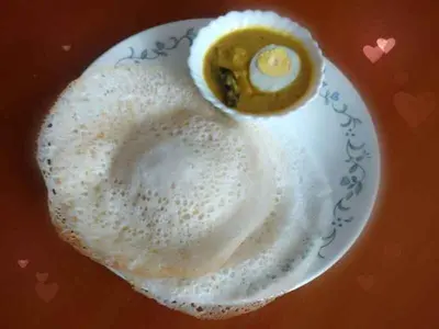 a white plate with an egg on top of it at Chamayam Holiday Villa in Meenangadi
