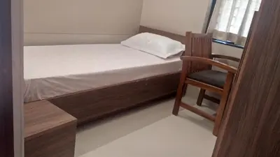 a small bedroom with a bed and a chair at LEMON RESIDENCY By Chungath in Trichūr