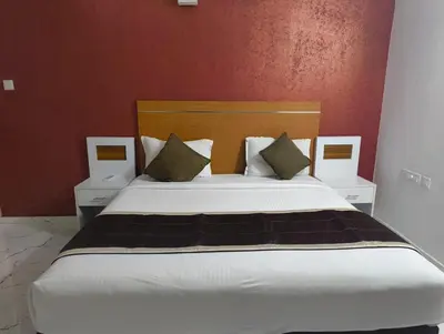 a bedroom with a large bed with two night stands at Utsavam Hotel Apartments in Guruvāyūr