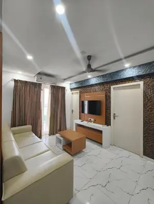 a living room with a couch and a tv at Utsavam Hotel Apartments in Guruvāyūr