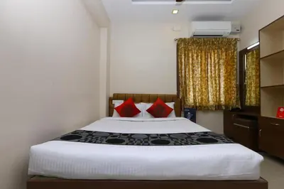 a bedroom with a large bed with red pillows at Sri Kamadhenu Residency in Coimbatore