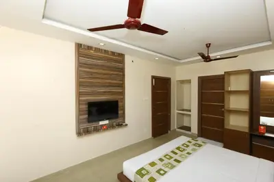 a bedroom with a ceiling fan and a tv at Sri Kamadhenu Residency in Coimbatore
