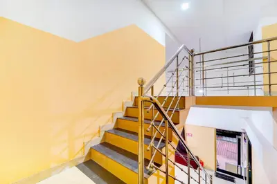 a staircase in a house with yellow walls at Super Hotel O Kunnamangalam Near Bus Stand in Calicut