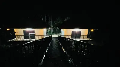 a building with two doors at night with lights at Caffeine Villa in Kaniyāmbetta