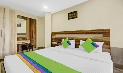 a bedroom with a large white bed and a desk at Treebo Darwesh Residency - 500m from Railway Station in Kozhikode