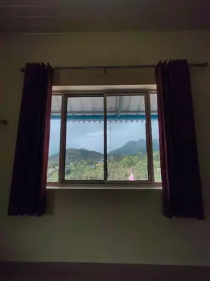 a window with a view of a mountain at Aden Valley in Kanthalloor