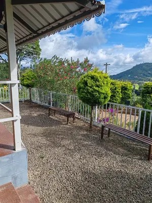 two benches sitting next to a fence with flowers at Aden Valley in Kanthalloor