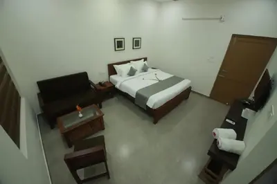 a bedroom with a bed and a desk and a chair at Green Planet Resort in Mattanūr