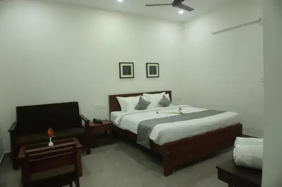 a bedroom with a bed and a nightstand and a bed sidx sidx sidx sidx at Green Planet Resort in Mattanūr