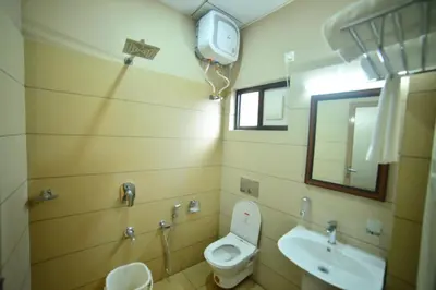 a bathroom with a toilet and a sink and a mirror at Hotel Priya in Kottakkal