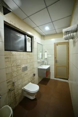a bathroom with a toilet and a sink at Hotel Priya in Kottakkal