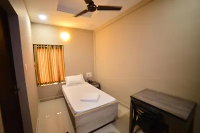 a small bathroom with a toilet and a ceiling fan at Hotel Priya in Kottakkal