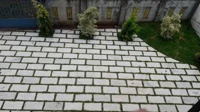 a brick walkway with bushes and a building at Wayanad Snow Vibes in Vythiri