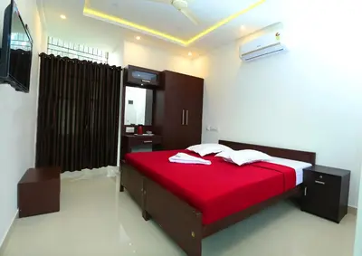 a bedroom with a red bed with a red blanket at karibu Residency in Malappuram