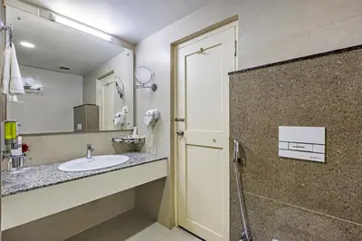 a bathroom with a sink and a mirror at Sterling Darshan Guruvayur in Guruvāyūr