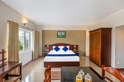 a bedroom with a bed and a table in a room at Sterling Darshan Guruvayur in Guruvāyūr
