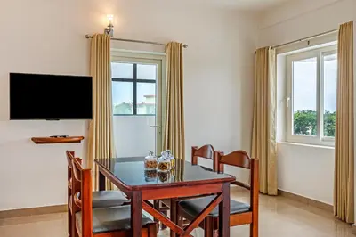 a dining room with a table and chairs and a television at Sterling Darshan Guruvayur in Guruvāyūr