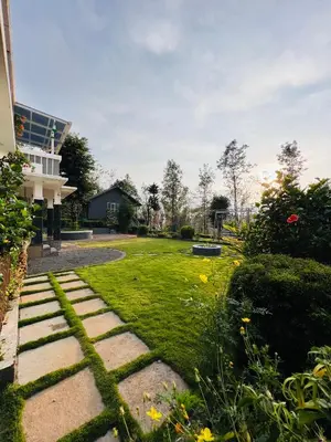 a garden with a stone pathway and grass at Villa Tesori Homestay Wayanad in Meppādi