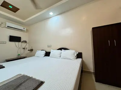 a bedroom with a bed with white sheets and white pillows at Sakthimurugan residency in Erode
