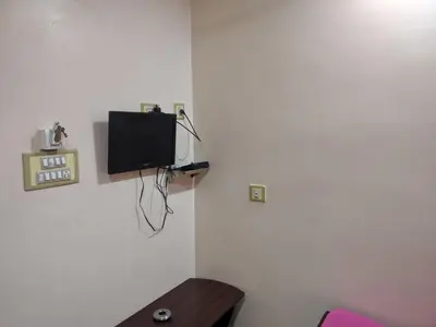 a corner of a room with a tv on the wall at Sakthimurugan residency in Erode