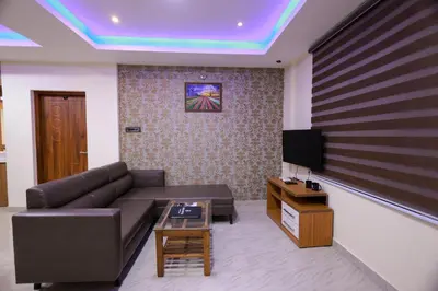 a living room with a couch and a tv at Builda Park inn in Ottappālam